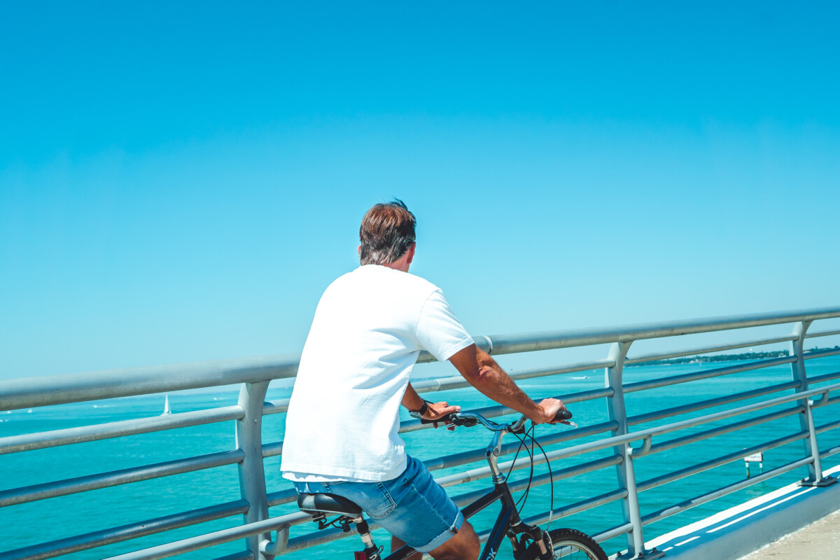 man riding his bike on Sarasota bridge