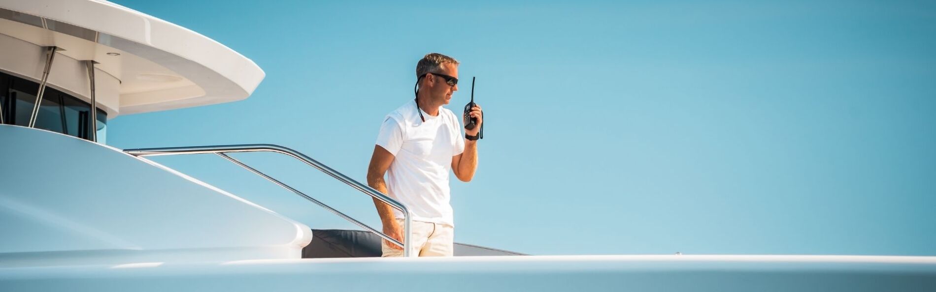 man on walkie talkie on yacht charter