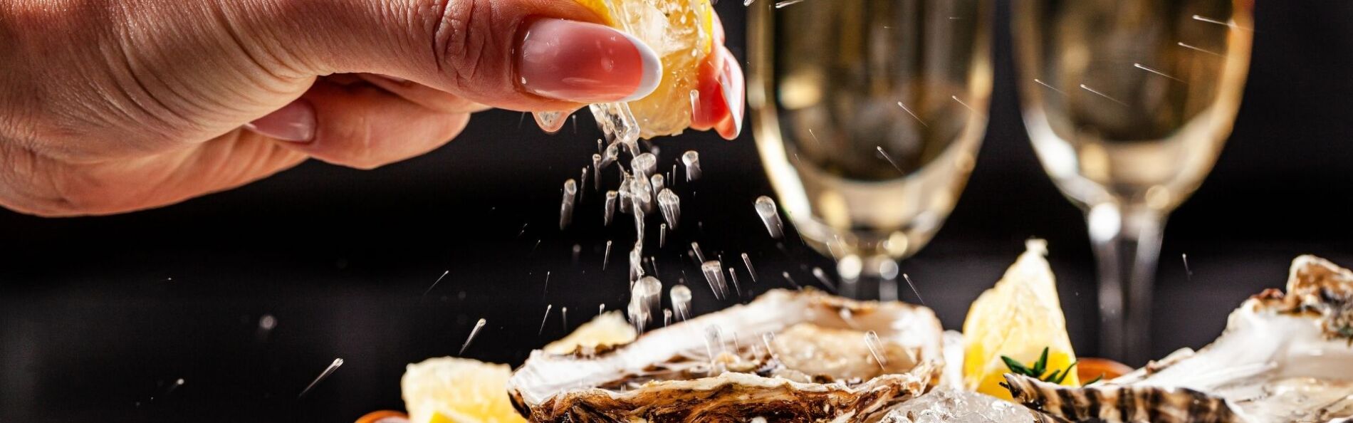 lemon juice being squeezed over fresh oysters
