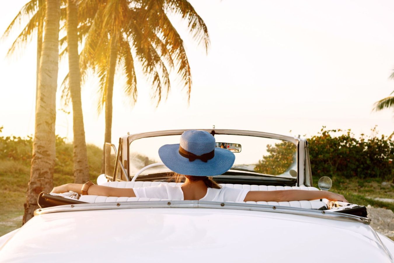woman enjoying beach view from luxury car